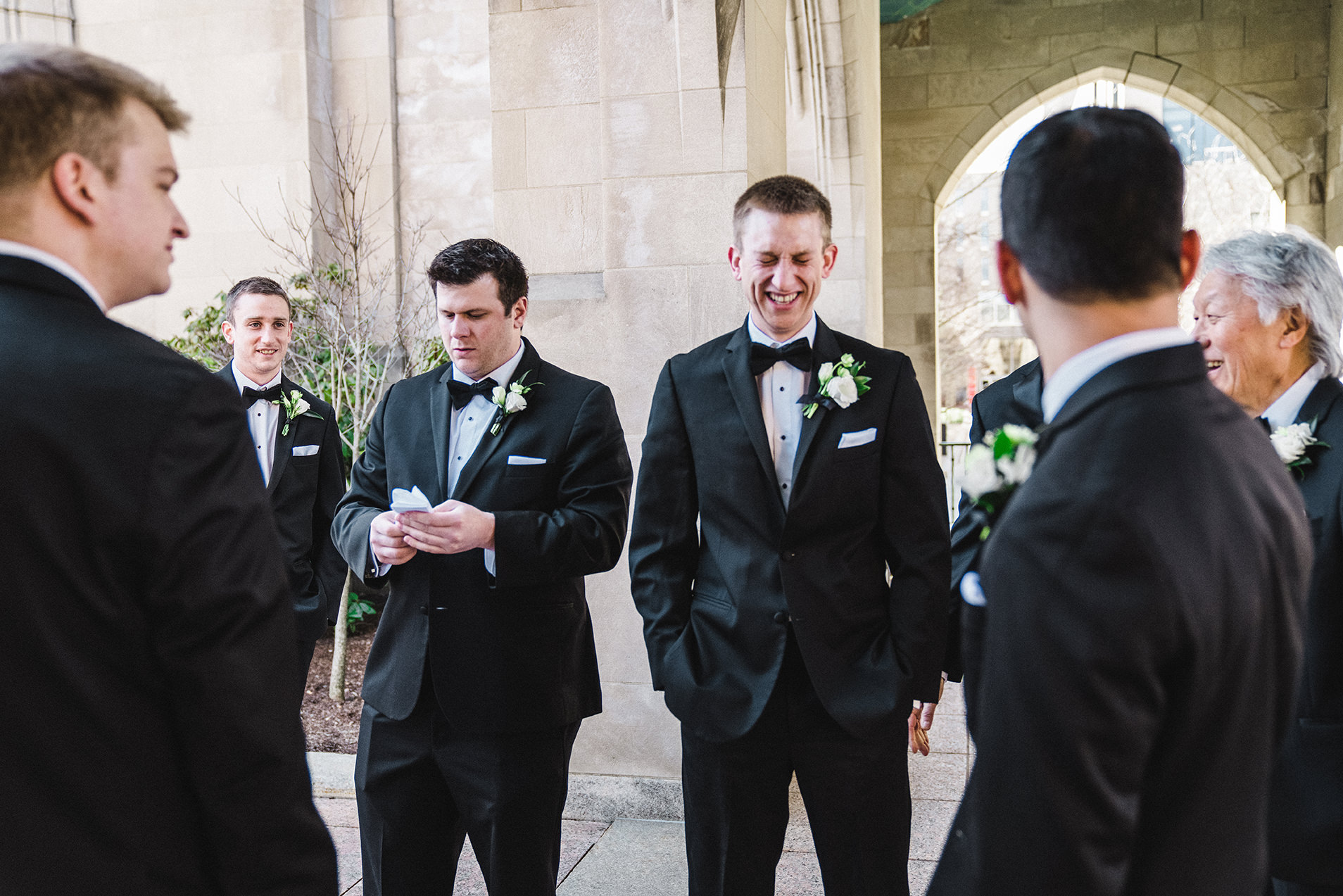 A documentary photograph of the groom and groomsmen talking and laughing before the ceremony of his Fairmont Copley Wedding in Boston