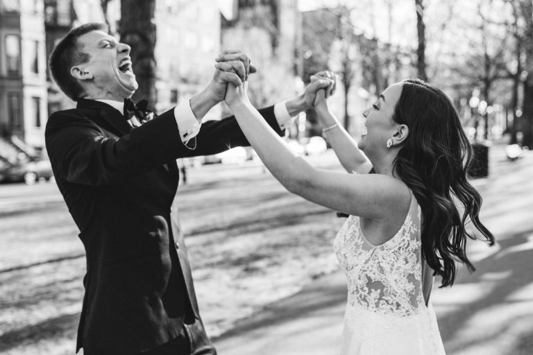 A candid portrait of a bride and groom celebrating on commonwealth mall after getting married in Boston