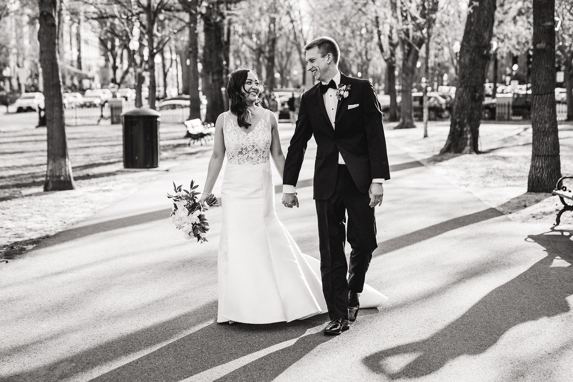 A candid portrait of a bride and groom walking down commonwealth mall during their fairmont copley wedding
