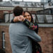 A documentary photograph of a couple hugging and laughing during their in home beacon hill engagement session in boston