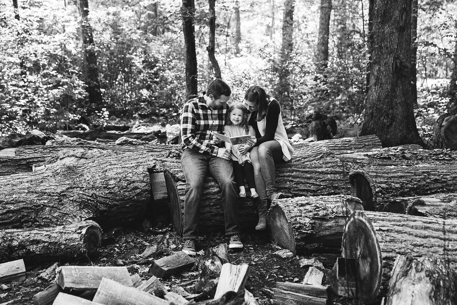 A documentary photograph of a family reading a book together outside during their family session at Borderland State Park