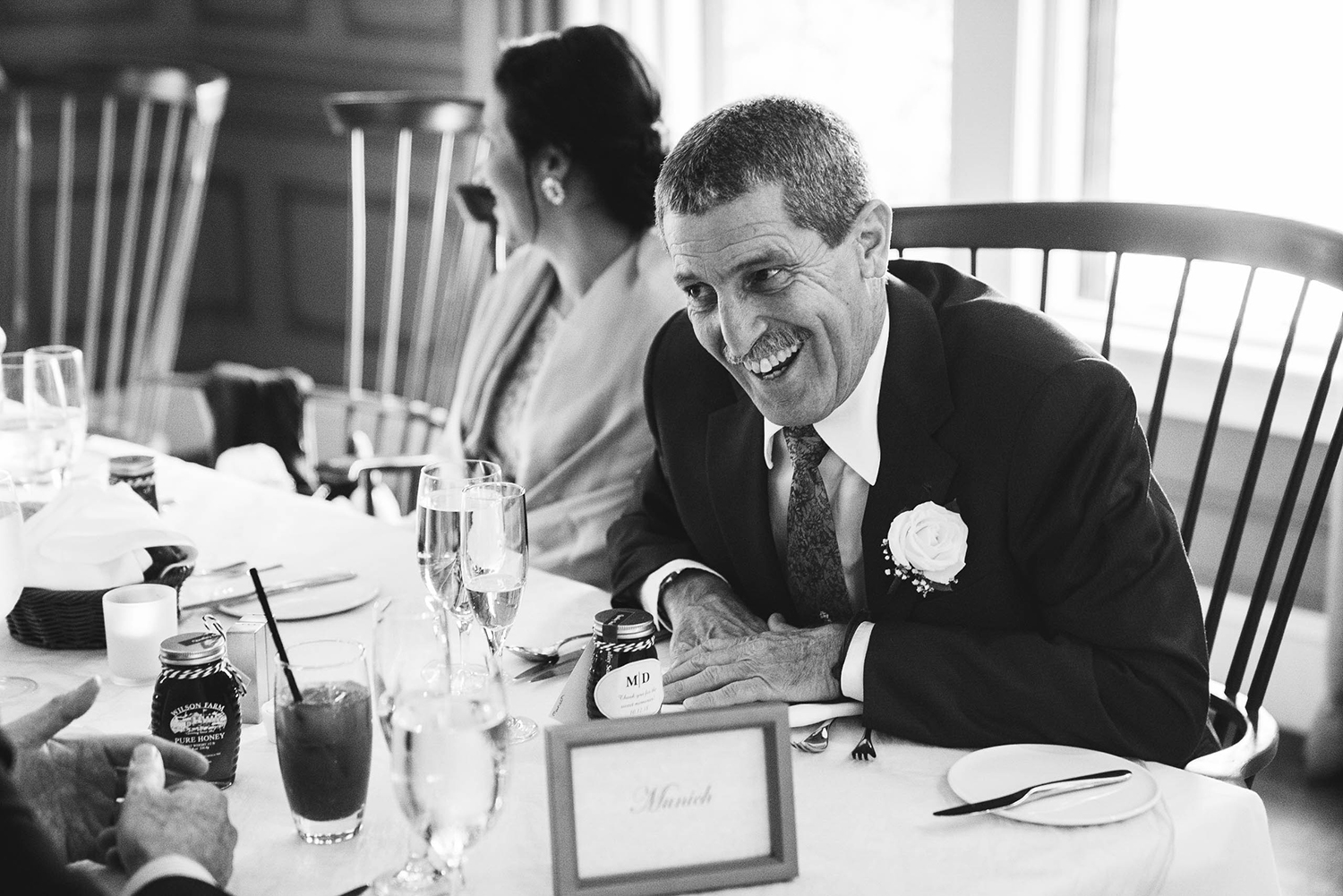 A documentary photograph of a father laughing during the wedding speeches at his daughter's Boston wedding