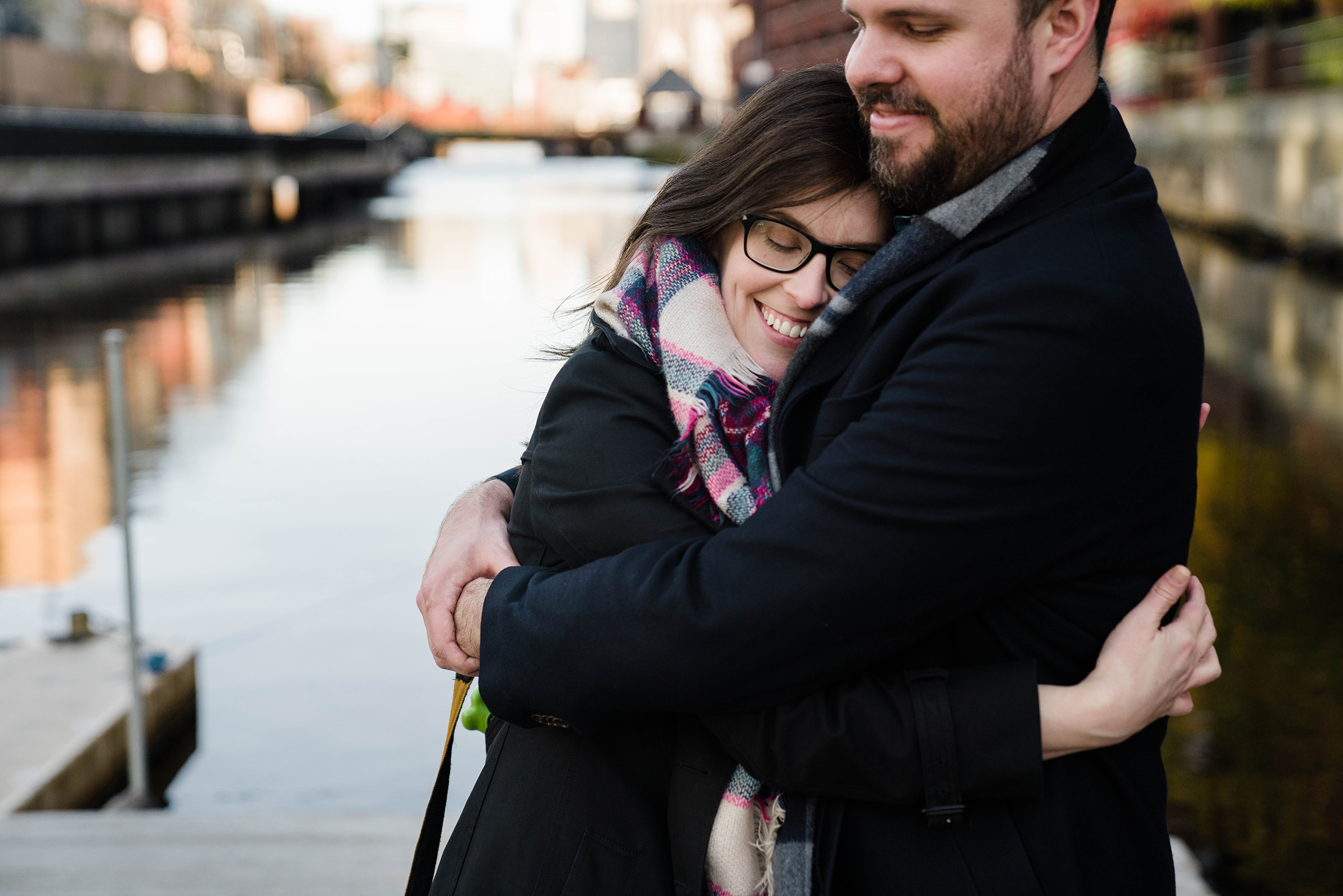 A documentary portrait of a couple hugging during their Cambridge engagement session 