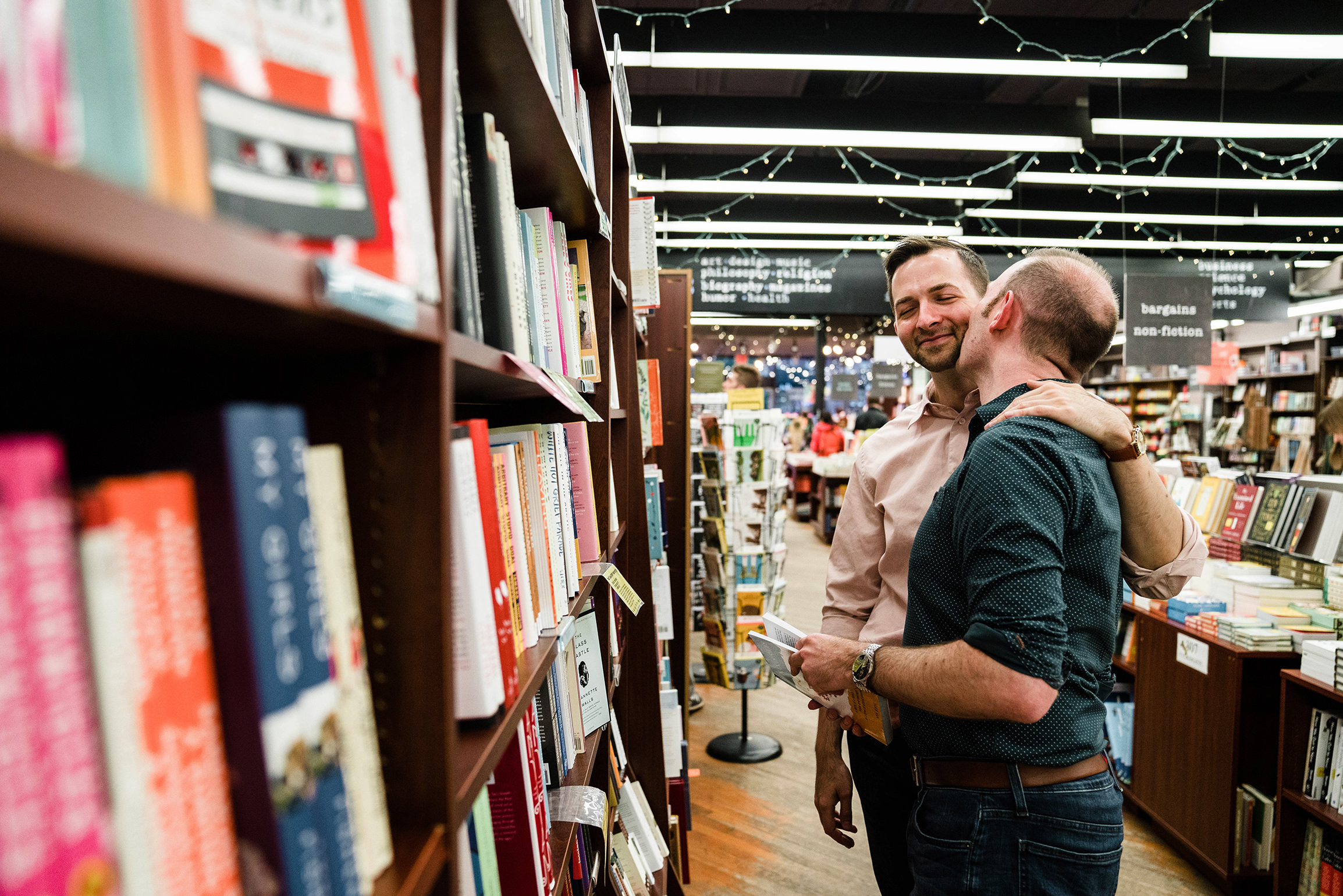A documentary photograph of a couple at a book store during their boston engagement session