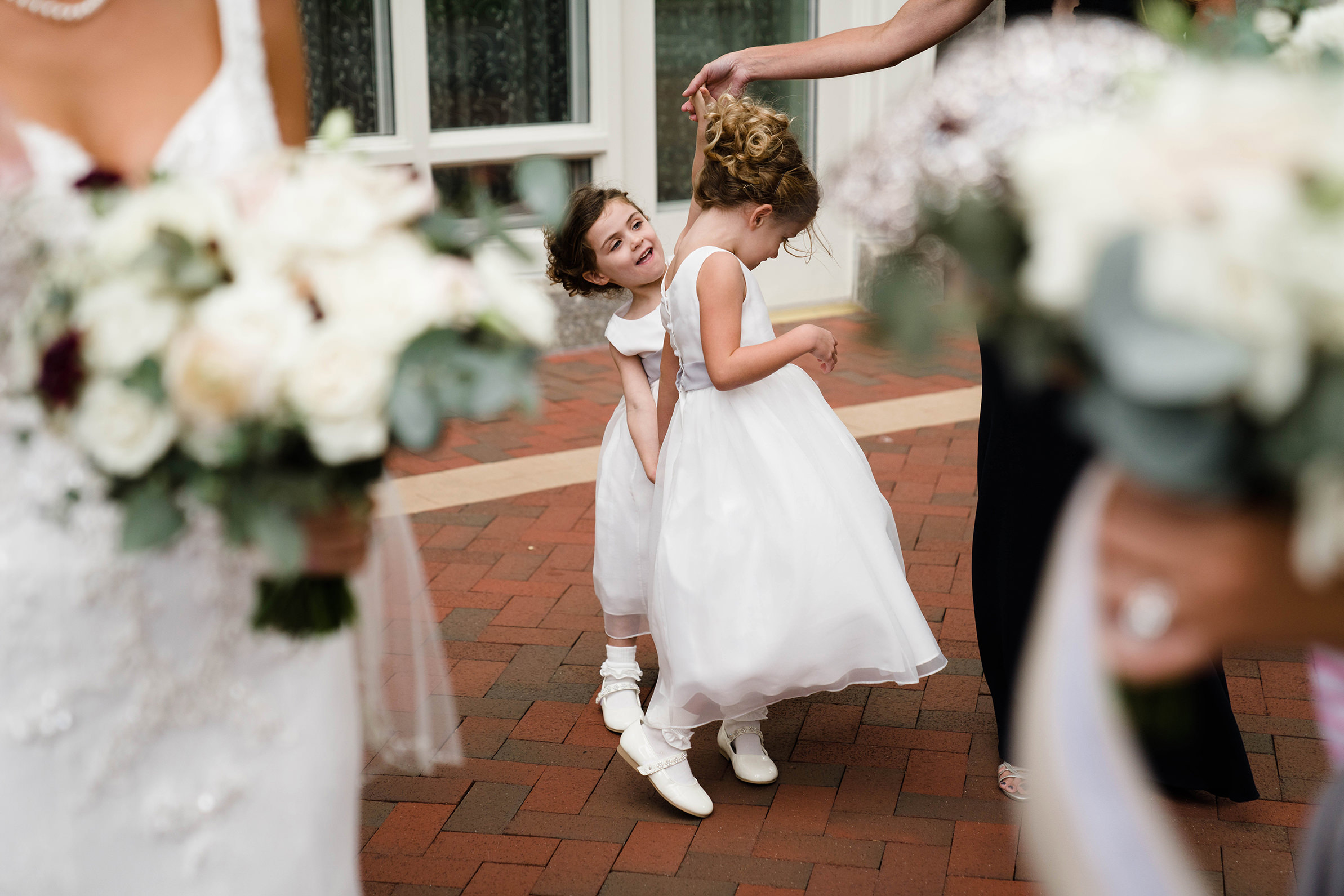 A best of Boston wedding photograph of flower girls dancing before the leave for the ceremony during a state room wedding