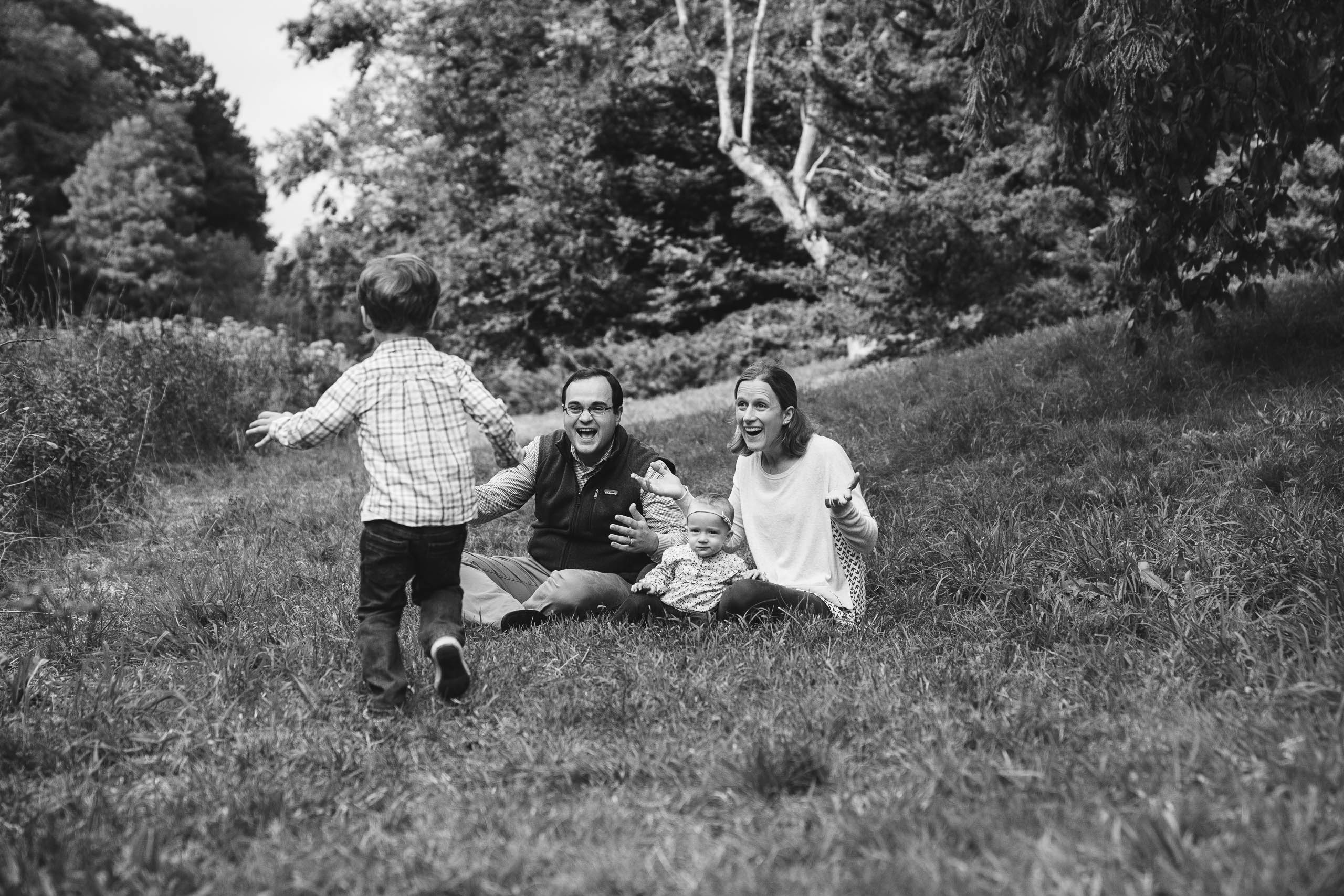 A best of Boston family photograph of a boy running to his family during a family session at the Arnold Arboretum in Boston