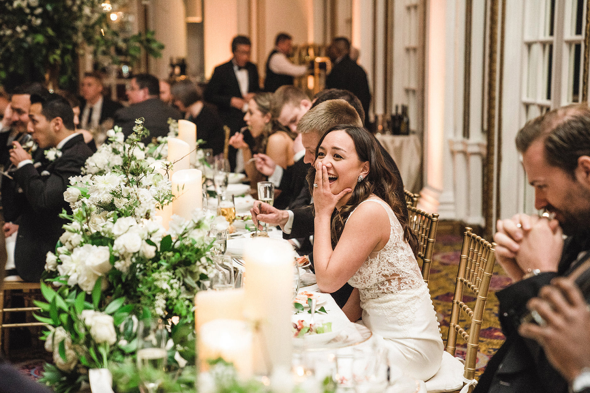 A best of Boston wedding photograph of a bride laughing during the wedding toasts at her Fairmont Copley wedding