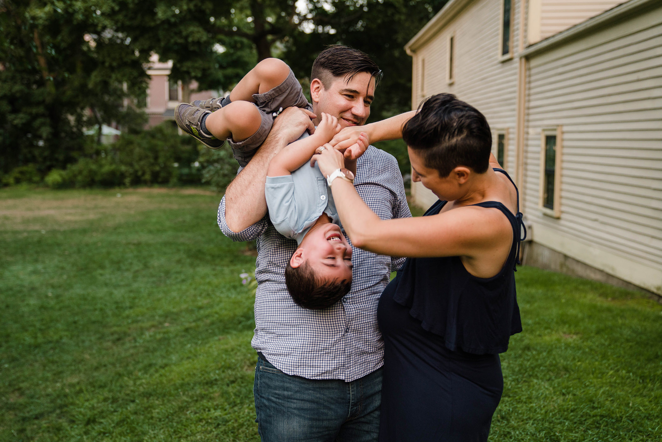 A best of Boston family photograph of a mom and dad tickling their son during an in home family session in Boston