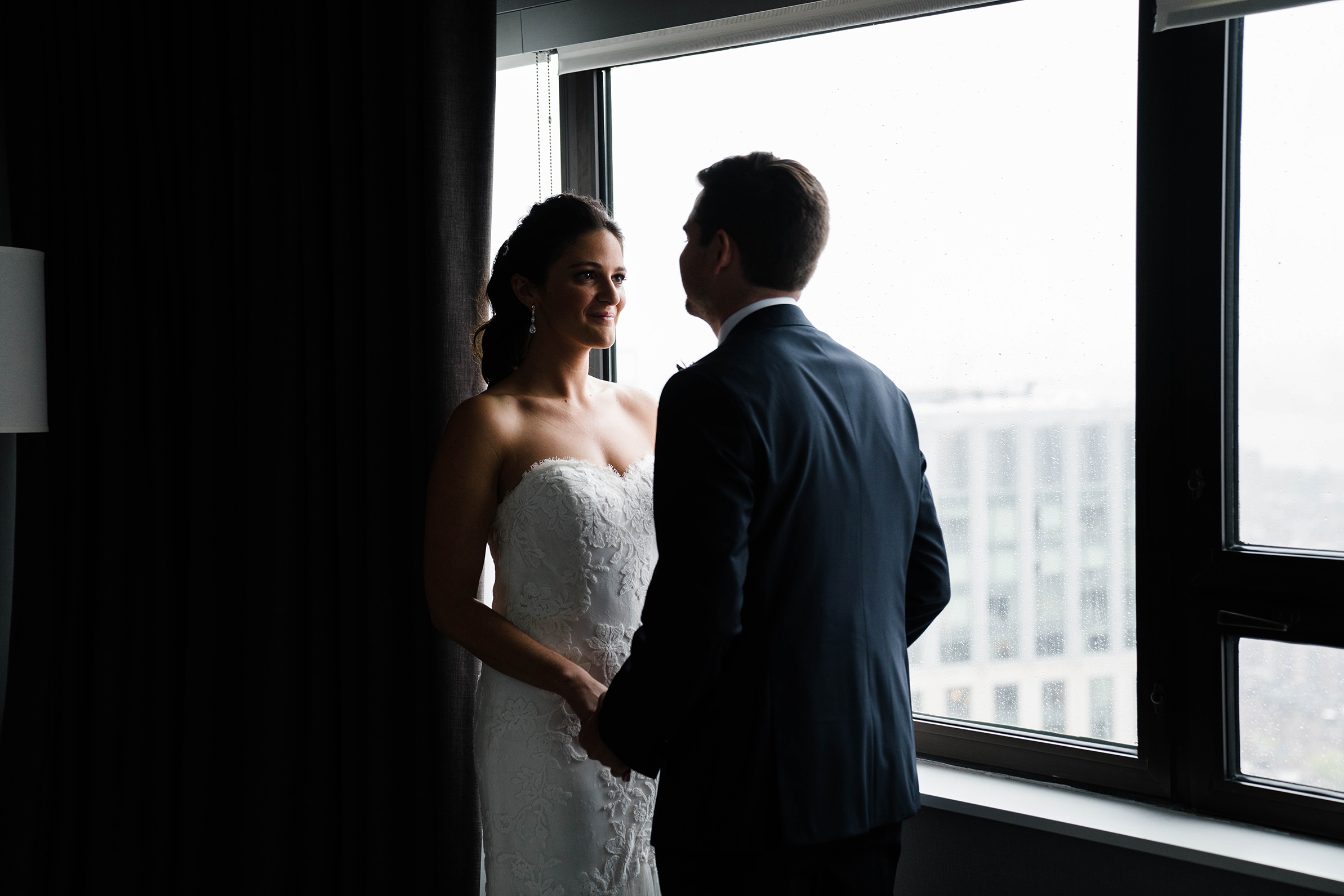 A best of Boston Wedding photograph of a couple having their first look in a hotel bedroom before their Cyclorama wedding on a rainy day