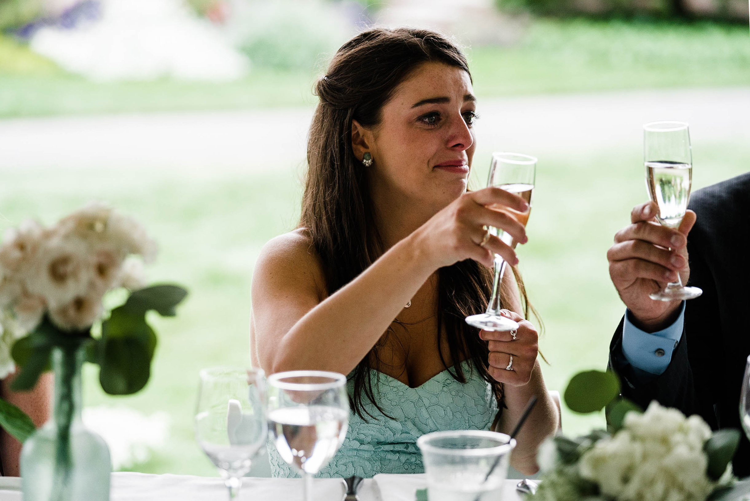 A best of Boston wedding photograph of a bridesmaid crying during the wedding toasts at a wedding in Plymouth, MA