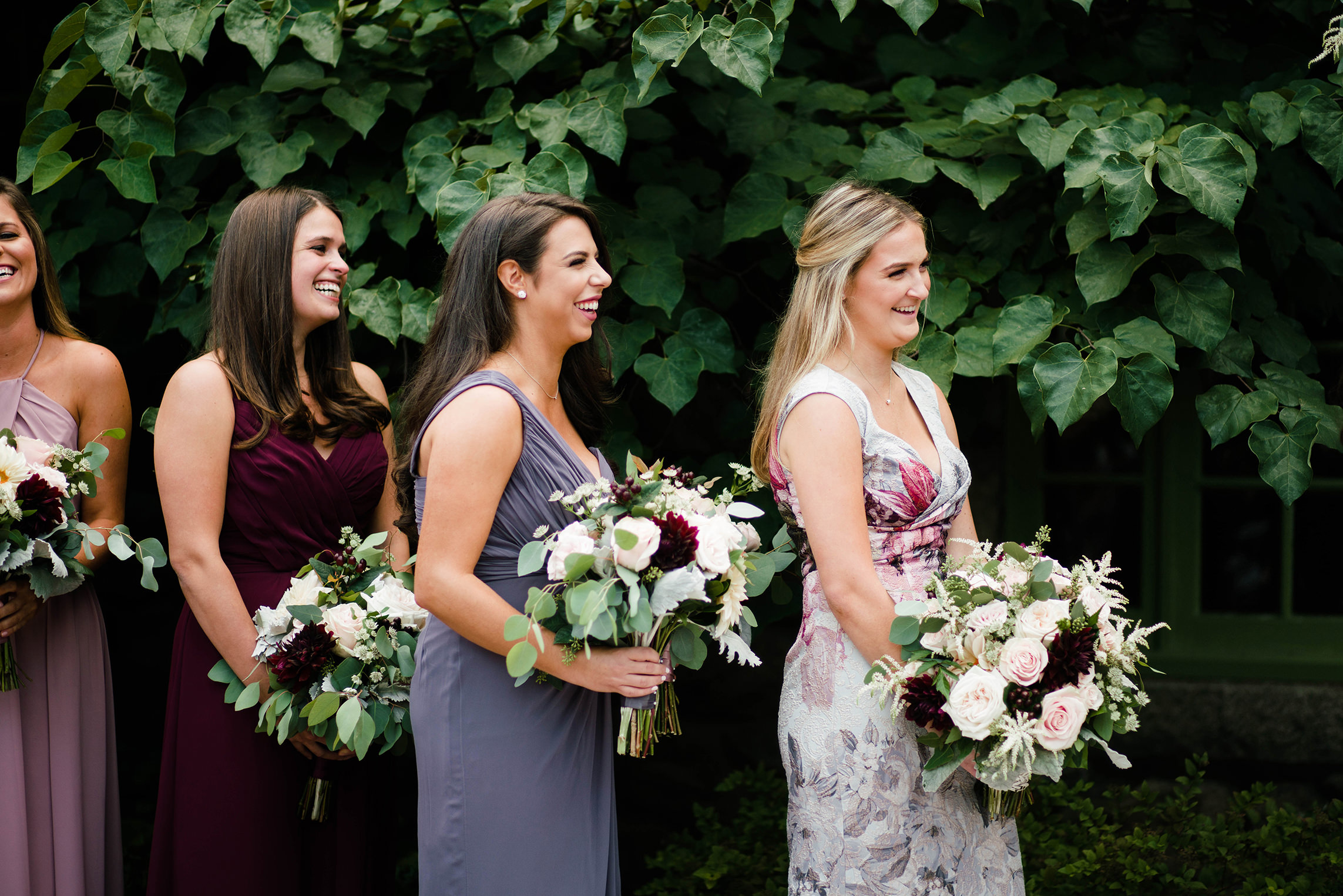 A best of Boston wedding photograph of bridesmaids laughing during a wedding ceremony at Willowdale estate