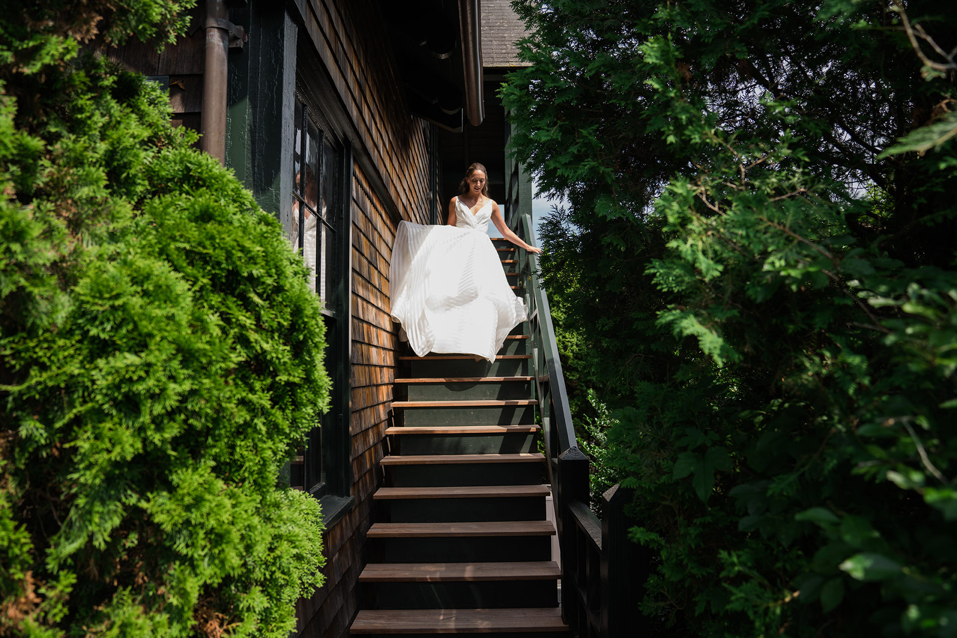 A best of Boston wedding photograph of a bride walking down the stairs before her Castle Hill Inn wedding