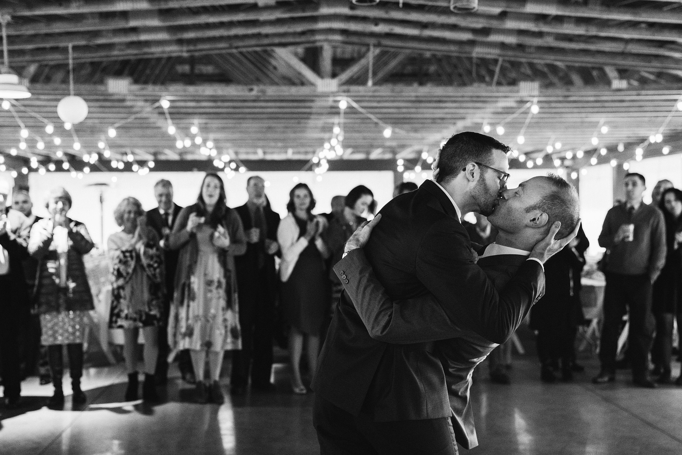 A best of Boston wedding photograph of two grooms kissing during their first dance at their German BSV club wedding