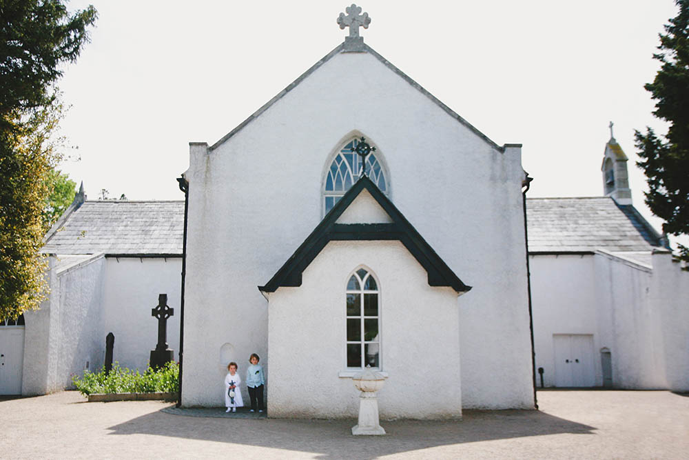 A documentary photograph of two children outside a church before a Boston Wedding
