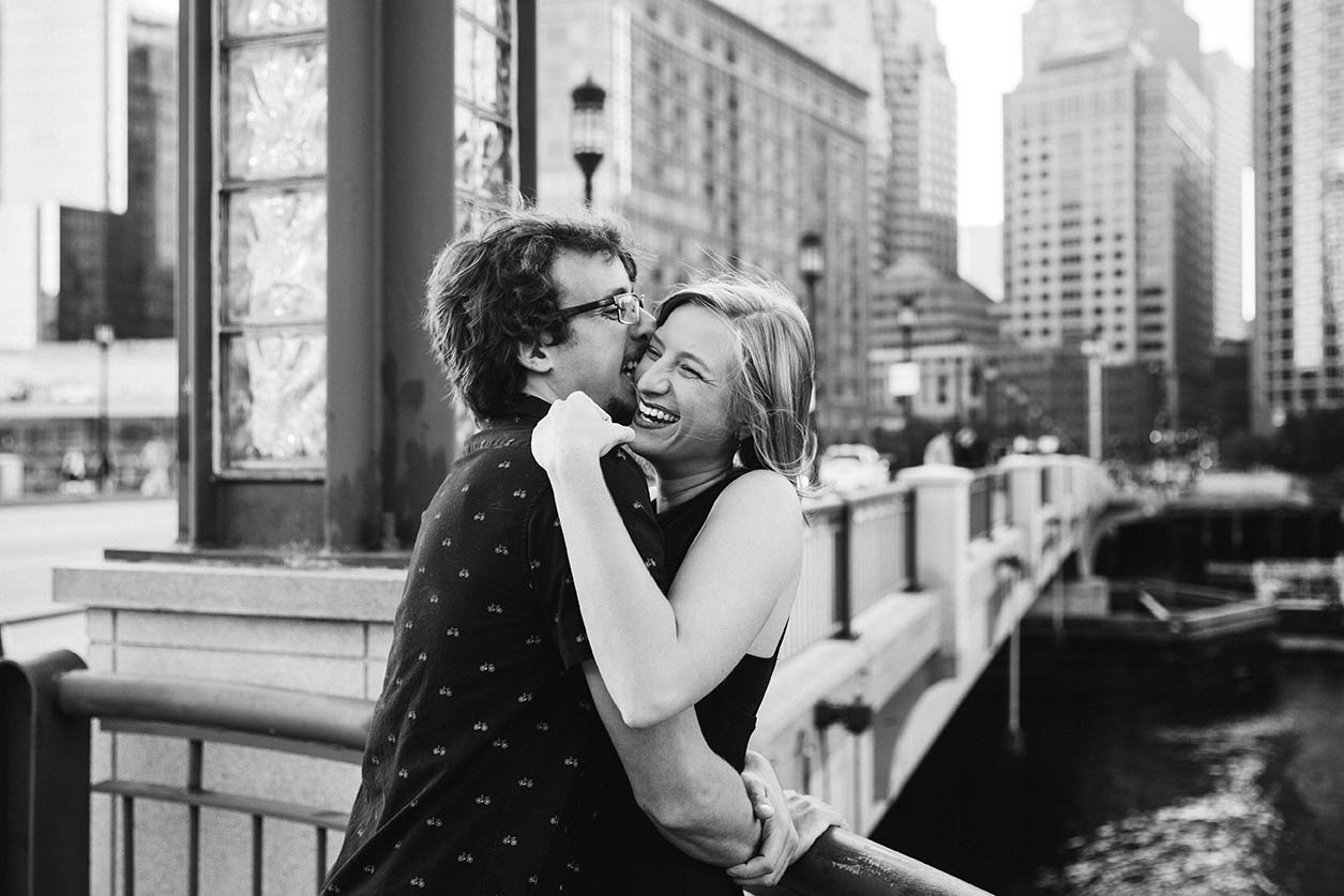 A documentary photograph of a couple hugging and laughing during their Boston Engagement session in the Seaport District