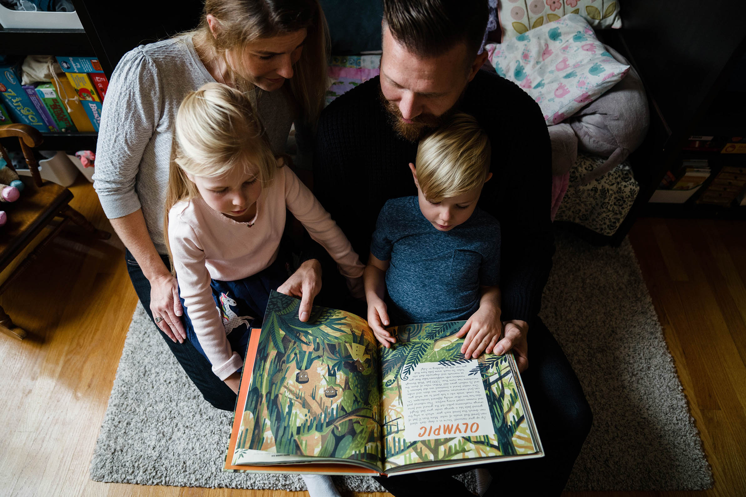 A documentary photograph of a family reading books during their in home family session in Boston
