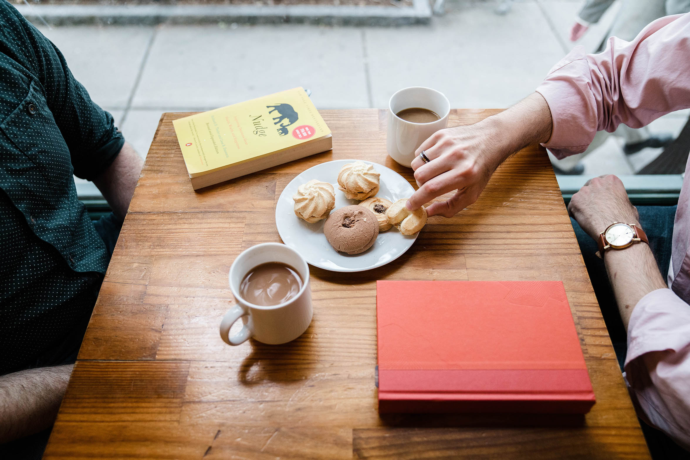 A documentary photograph of a couple sharing cookies and coffee during their Brookline engagement session in Boston