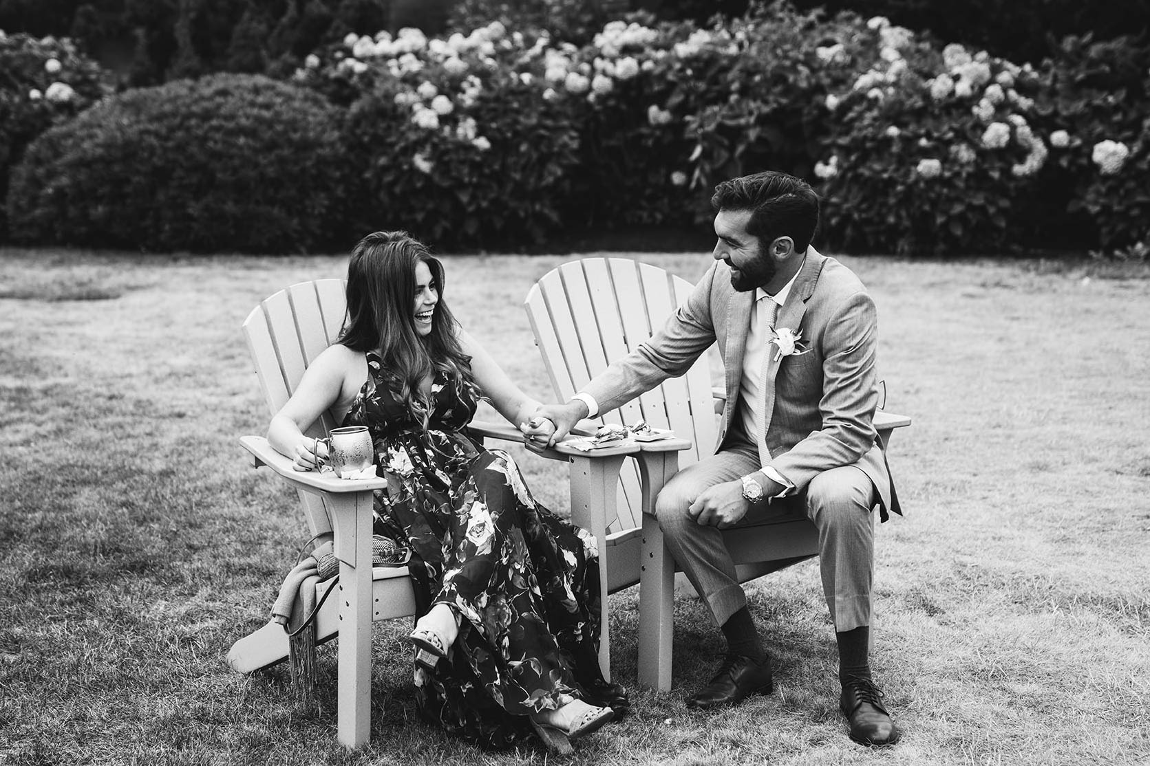A documentary photograph of a couple talking and laughing during a Castle Hill Inn Wedding outside of Boston
