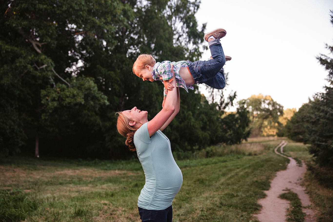 A documentary photograph of a pregnant mom playing with her son during a maternity family session at the Arnold Arboretum in Boston