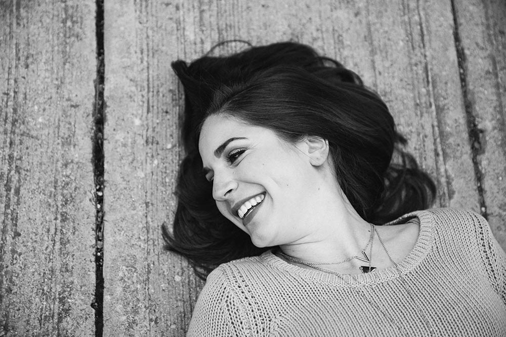 A documentary portrait of a girl laughing during her Boston engagement session