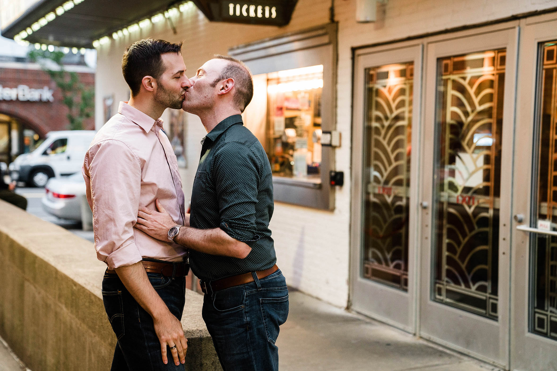 A documentary engagement session of a couple kissing outside of a movie theater during their Boston Engagement Session