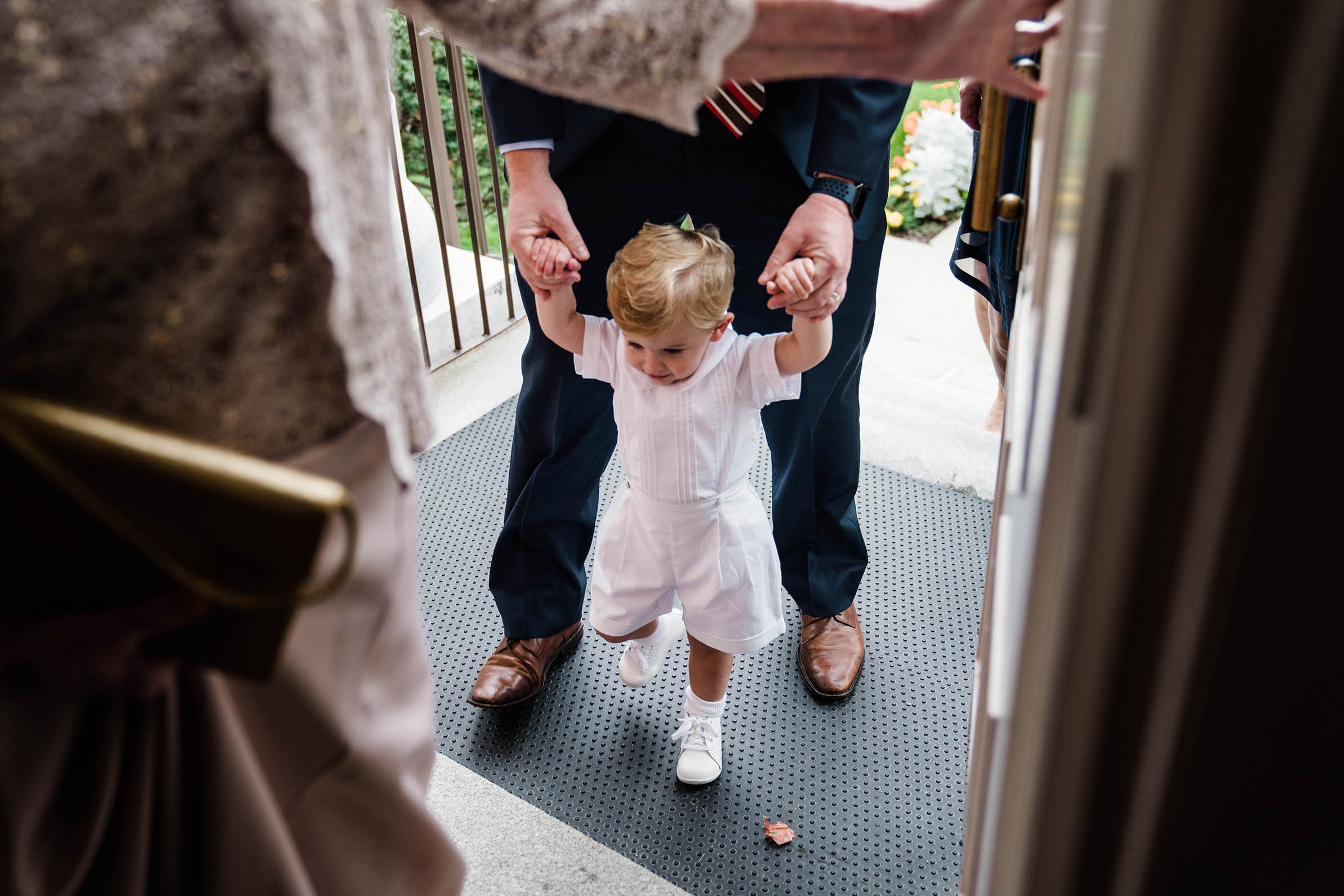 A documentary photograph of a boy walking into the church with his parents before a Boston wedding ceremony