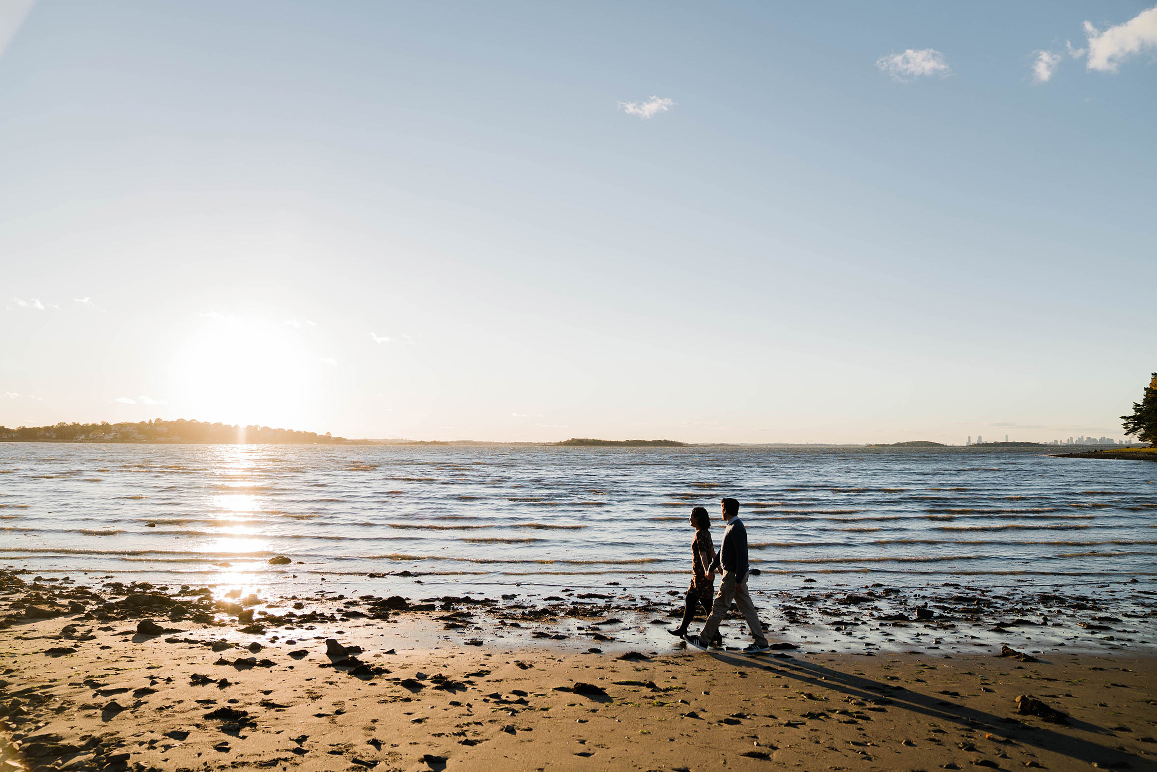 A documentary photograph of couple walking on the beach during their World's End Engagement Session in Boston