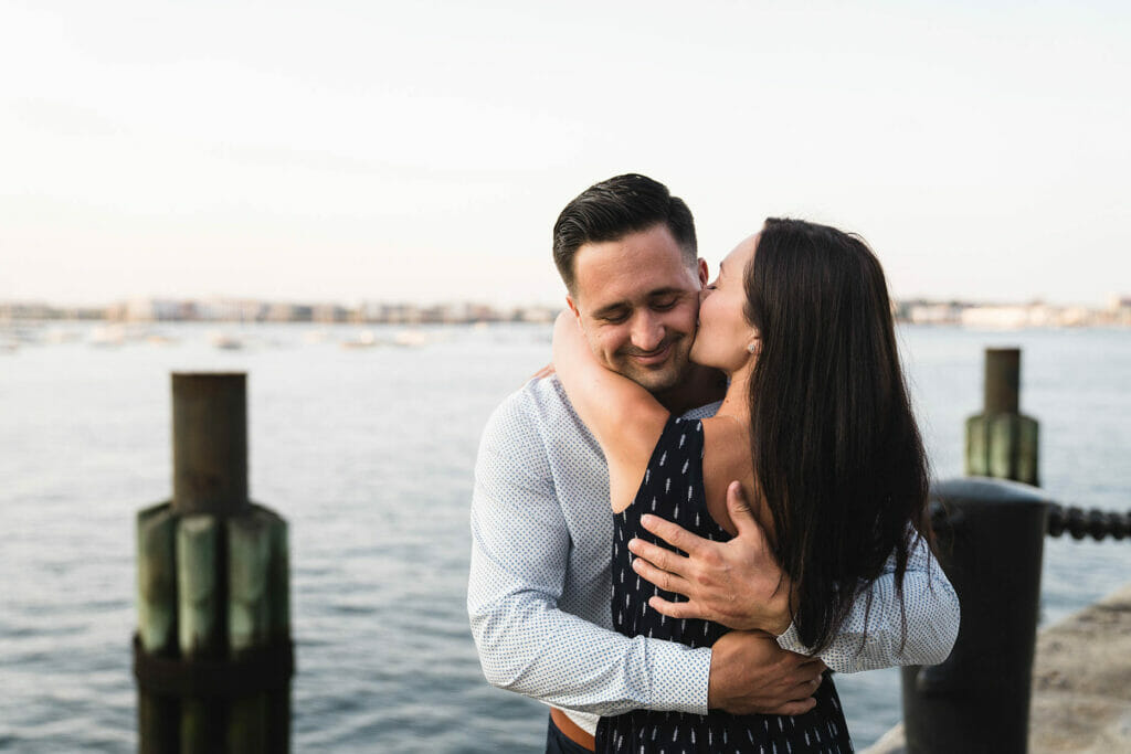 A documentary photograph of a couple hugging during their Boston Engagement Session at Fan Pier