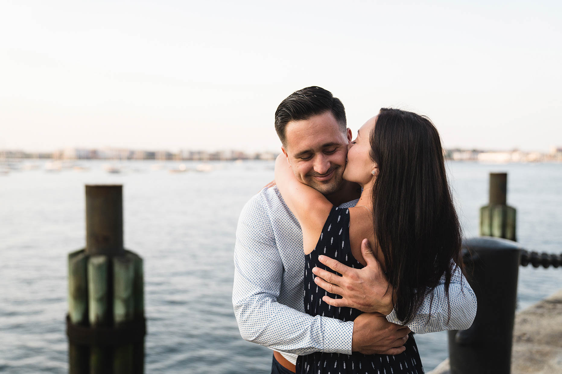 A documentary photograph of a couple hugging during their Boston Engagement Session at Fan Pier