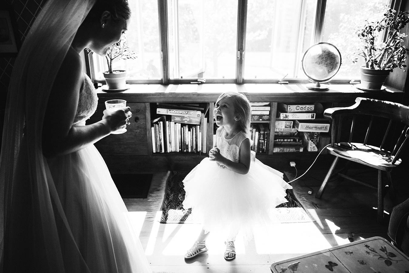A documentary photograph of an excited flower girl with a bride before a Boston wedding