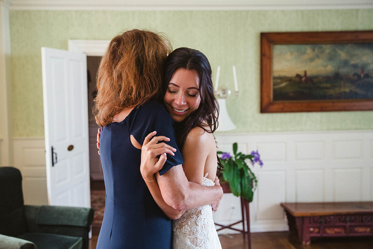 A documentary photograph of a bride hugging her mom before her Boston wedding ceremony