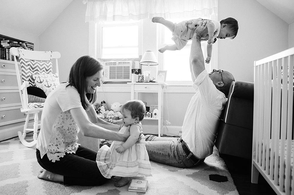 A documentary photograph of a family playing together during their in home family session in Boston
