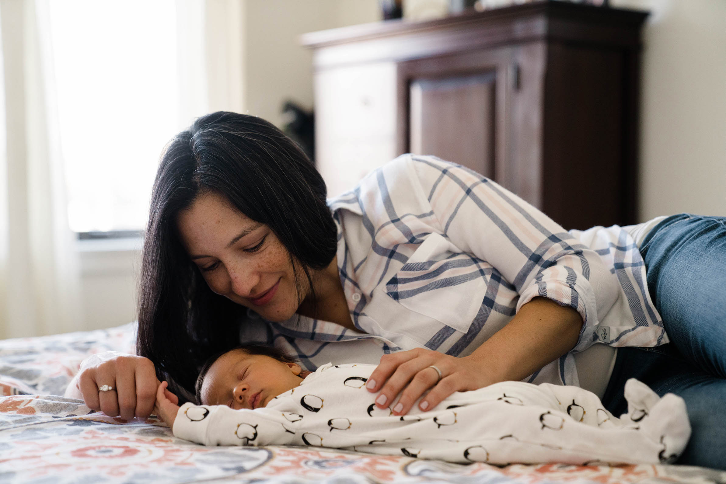 A documentary photograph of a mom and her newborn son during an in home newborn session in Boston