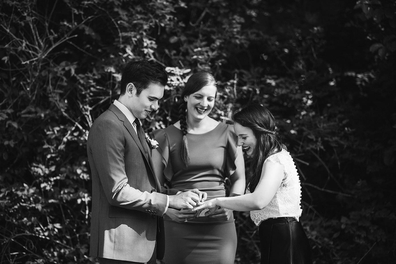 A documentary photograph of a bride and groom saying their vows during an outdoor wedding ceremony at home outside of Boston