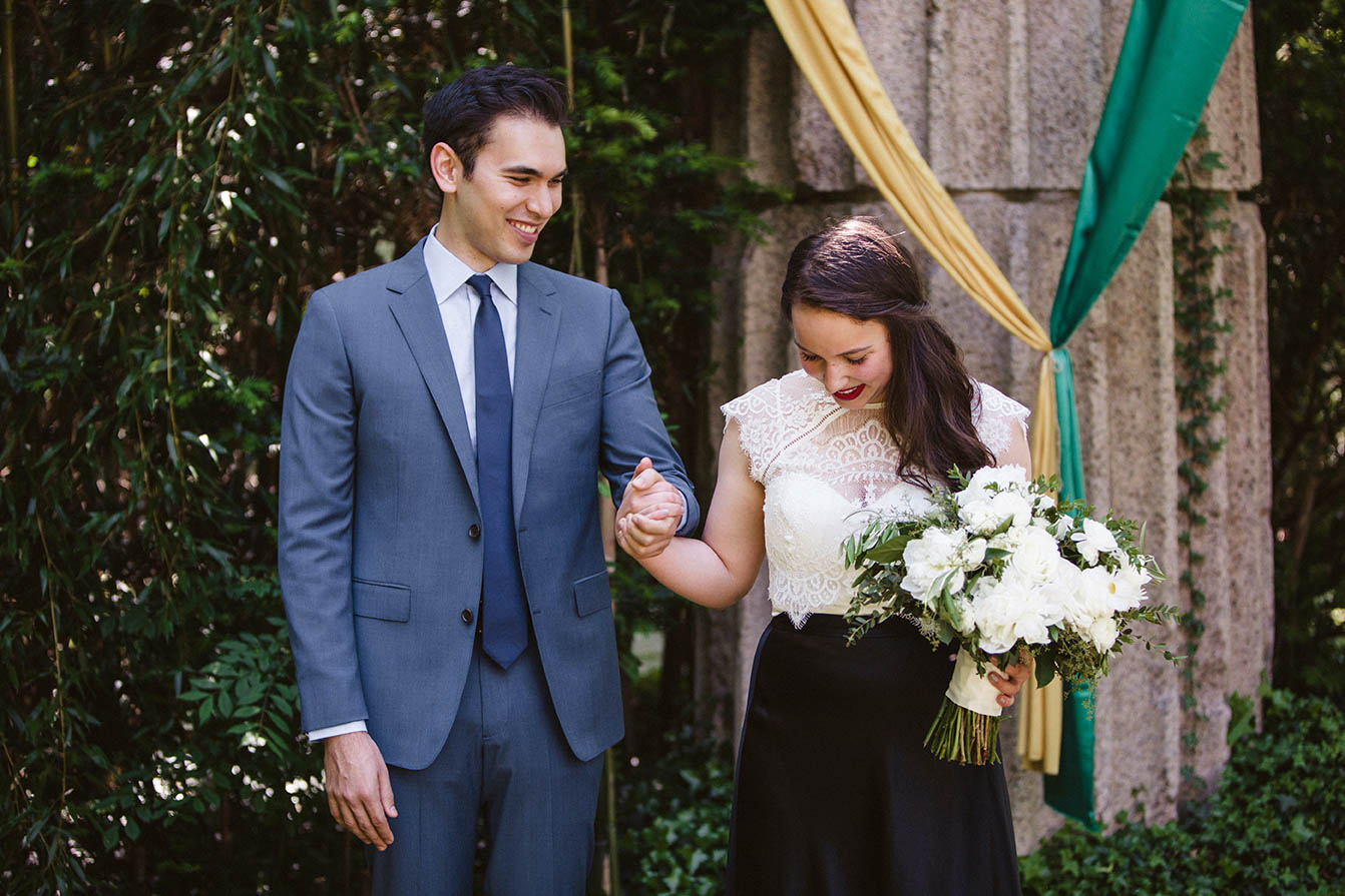 A documentary portrait of a bride and groom walking together before their outdoor wedding ceremony at home on Cape Cod
