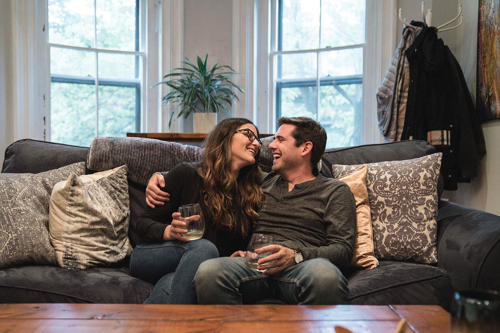 A documentary portrait of a couple hanging out on their couch in their South End home during their Boston engagement session