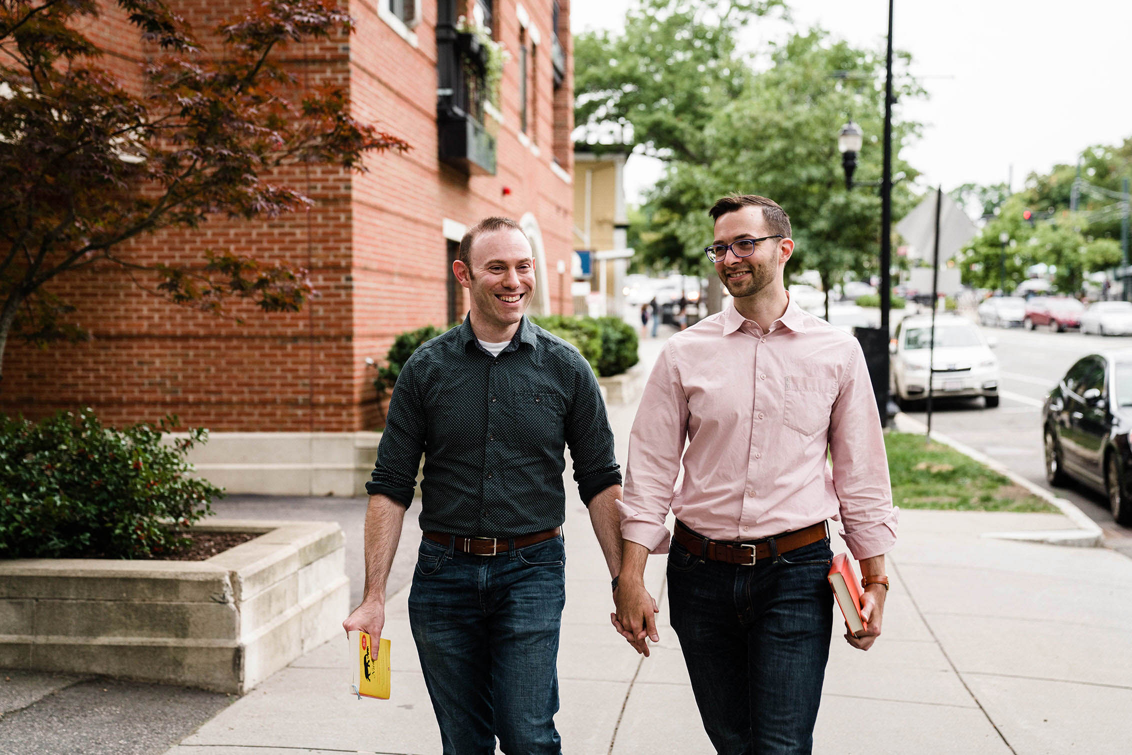 A documentary portrait of a couple walking down the street together during their Boston engagement session