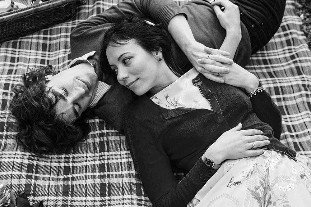 A documentary portrait of a couple laying on a blanket together during their Boston engagement session