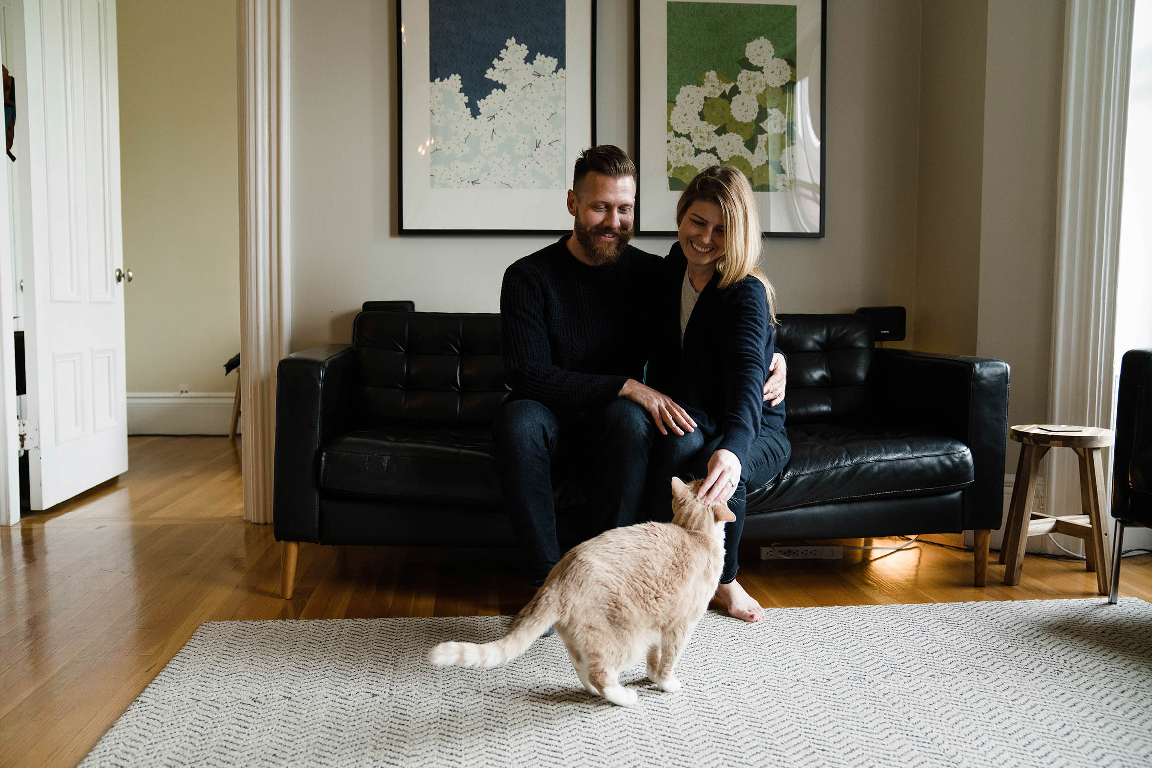 A documentary photograph of parents petting their cat during an in home family session in Boston's south end