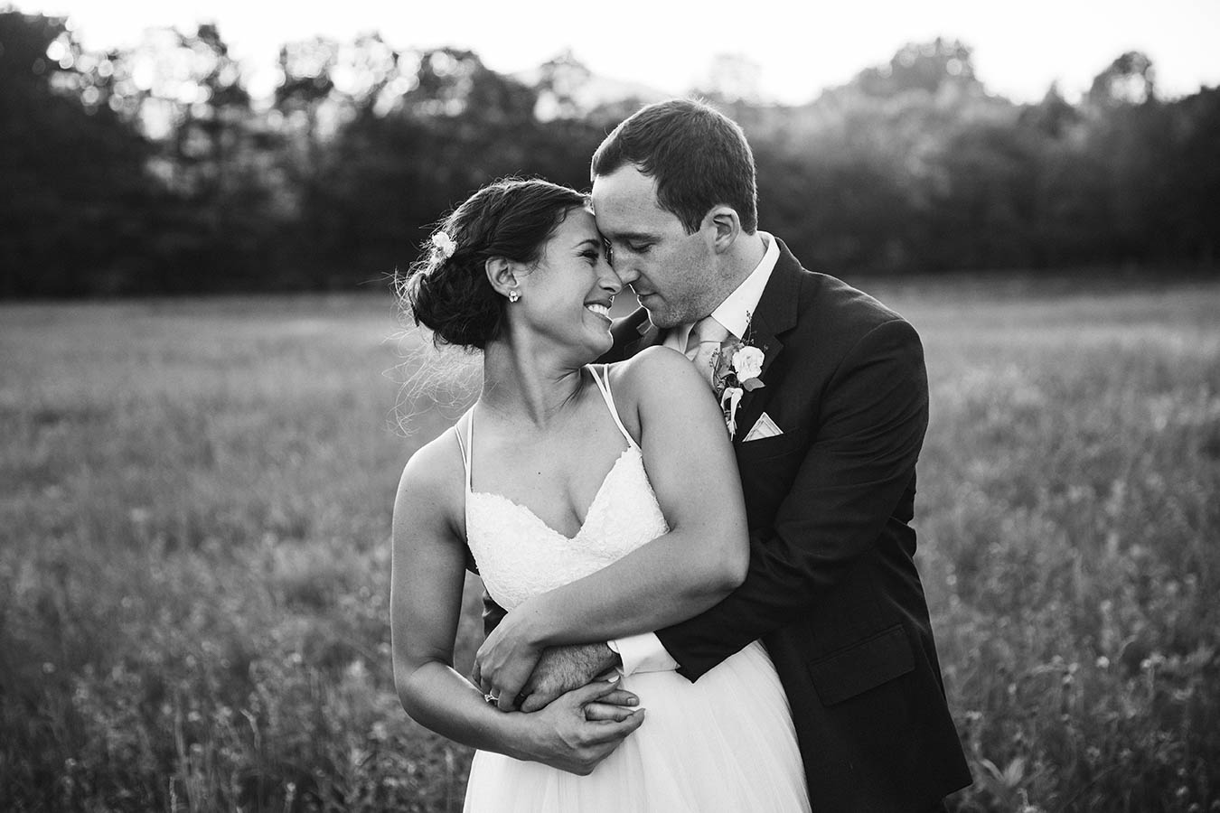 A documentary portrait of a couple hugging during their moody mountain farm wedding