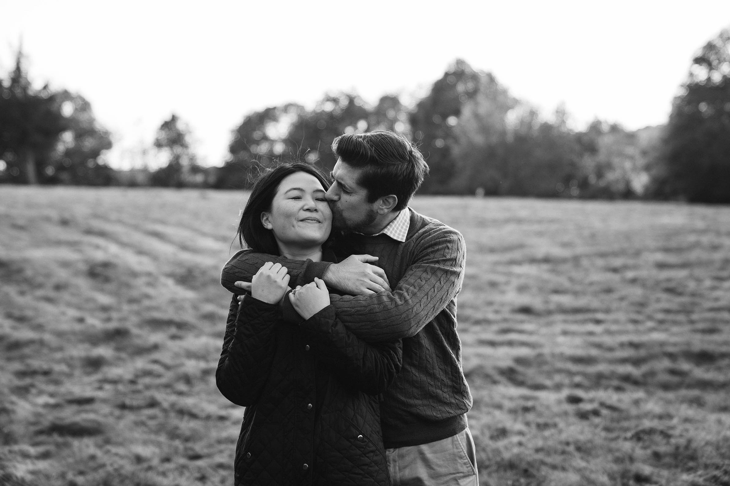 A documentary portrait of a couple hugging at the World's End during their Boston engagement session