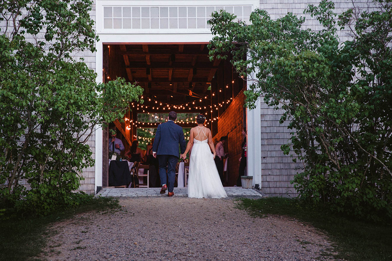 A documentary photograph of a bride and groom walking into their wedding reception at Moody Mountain Farm