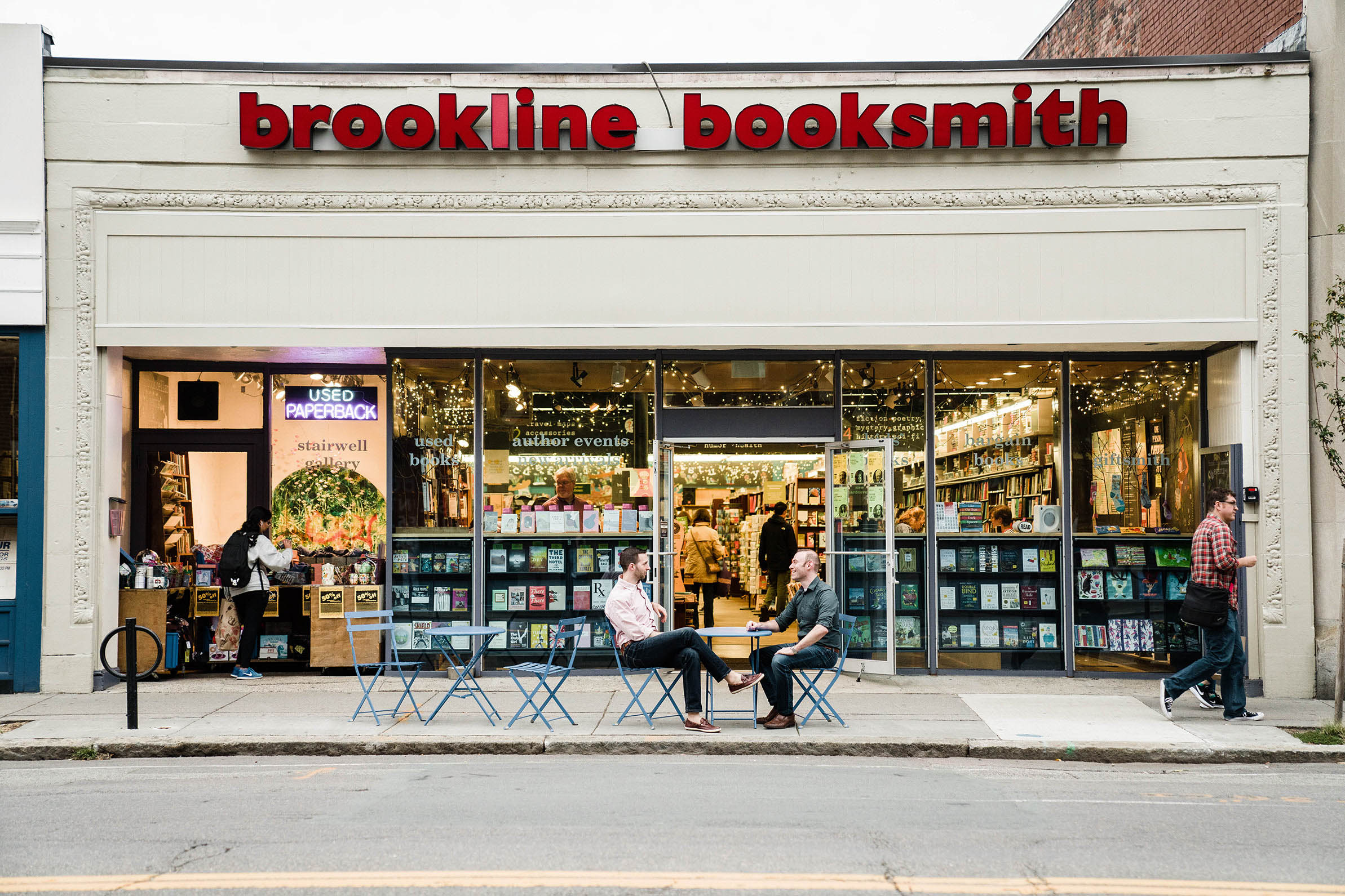 A documentary portrait of a couple sitting outside of their favorite book store during their Boston engagement session