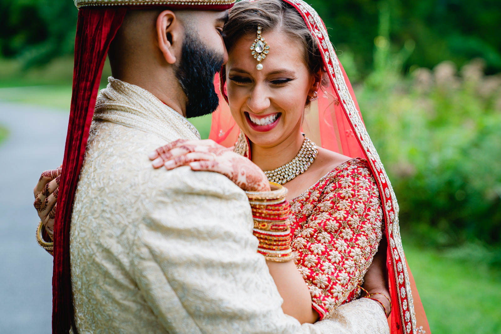 A documentary portrait of a bride and groom hugging during the first look before their Indian American wedding in Boston