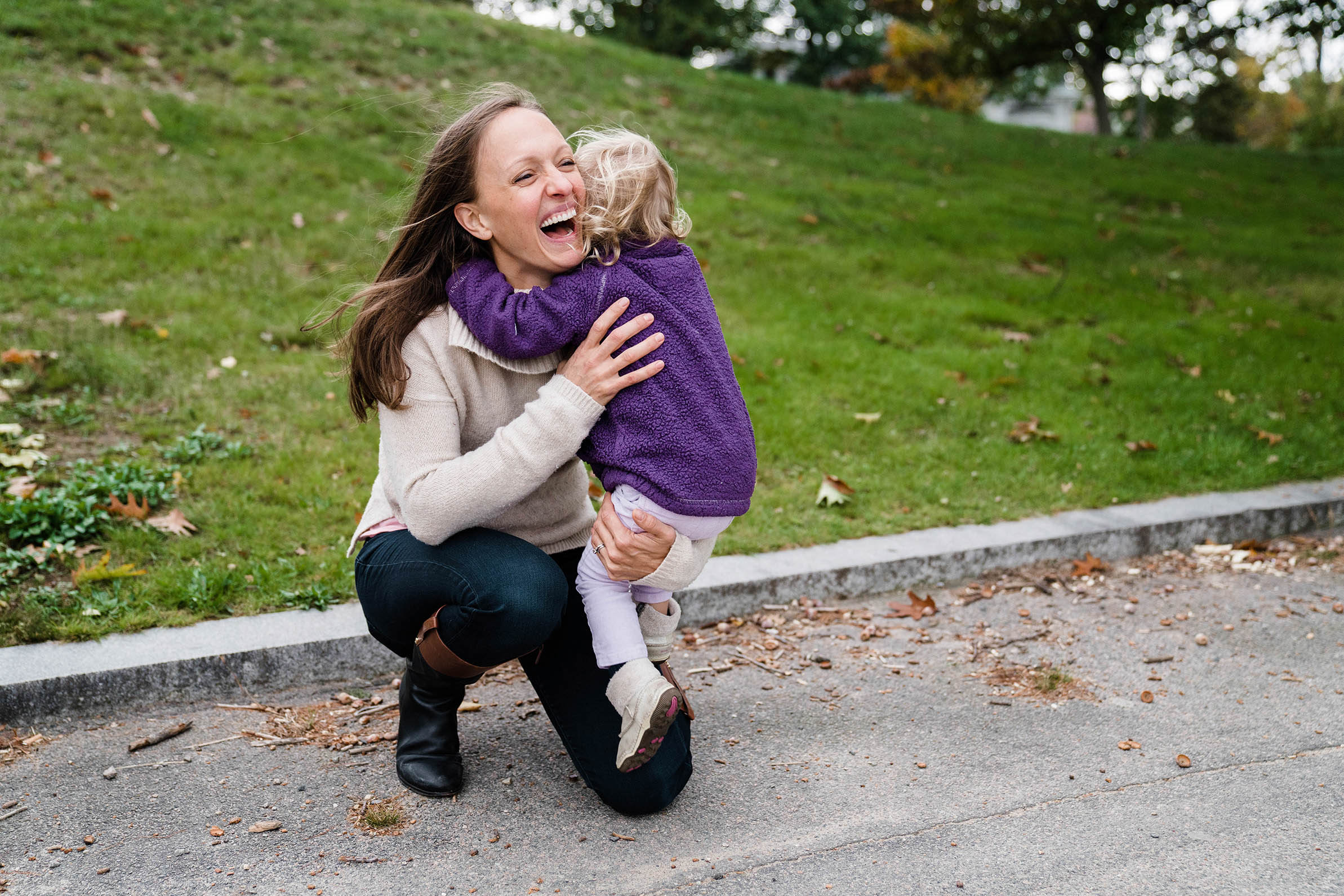 A documentary photograph of a mom hugging her daughter during their family session at Jamaica Pond in Boston