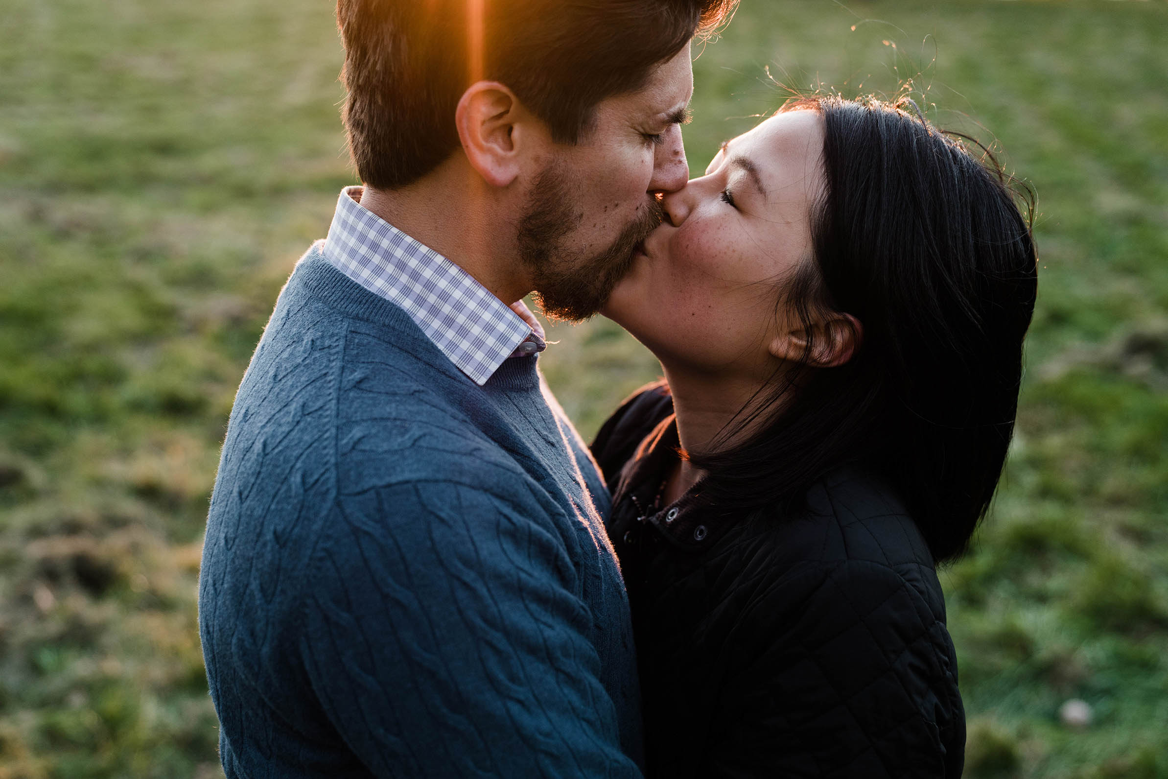 A documentary portrait of a couple hugging and kissing at the World's End during their Boston engagement session
