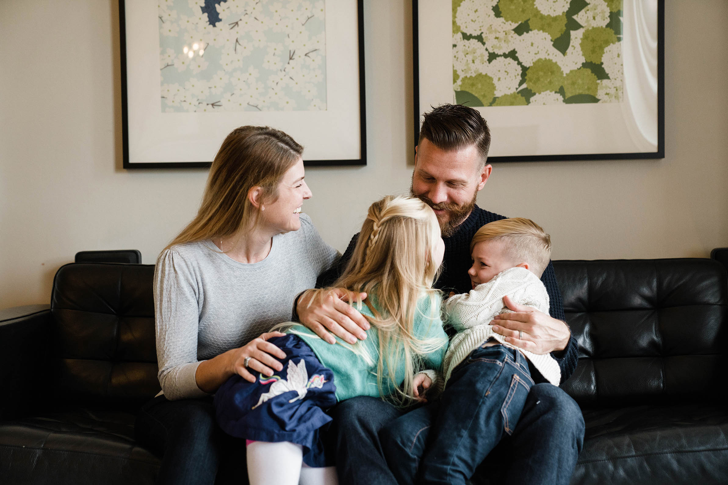 A documentary photograph of a family snuggling on the couch during their in home family session in Boston's South End