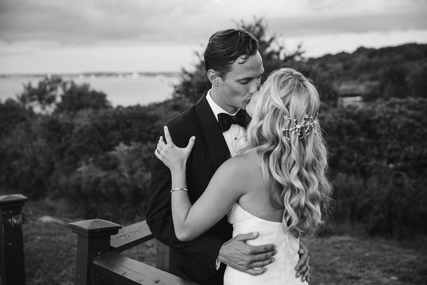 A documentary portrait of a couple sharing a kiss during their Castle Hill Inn wedding