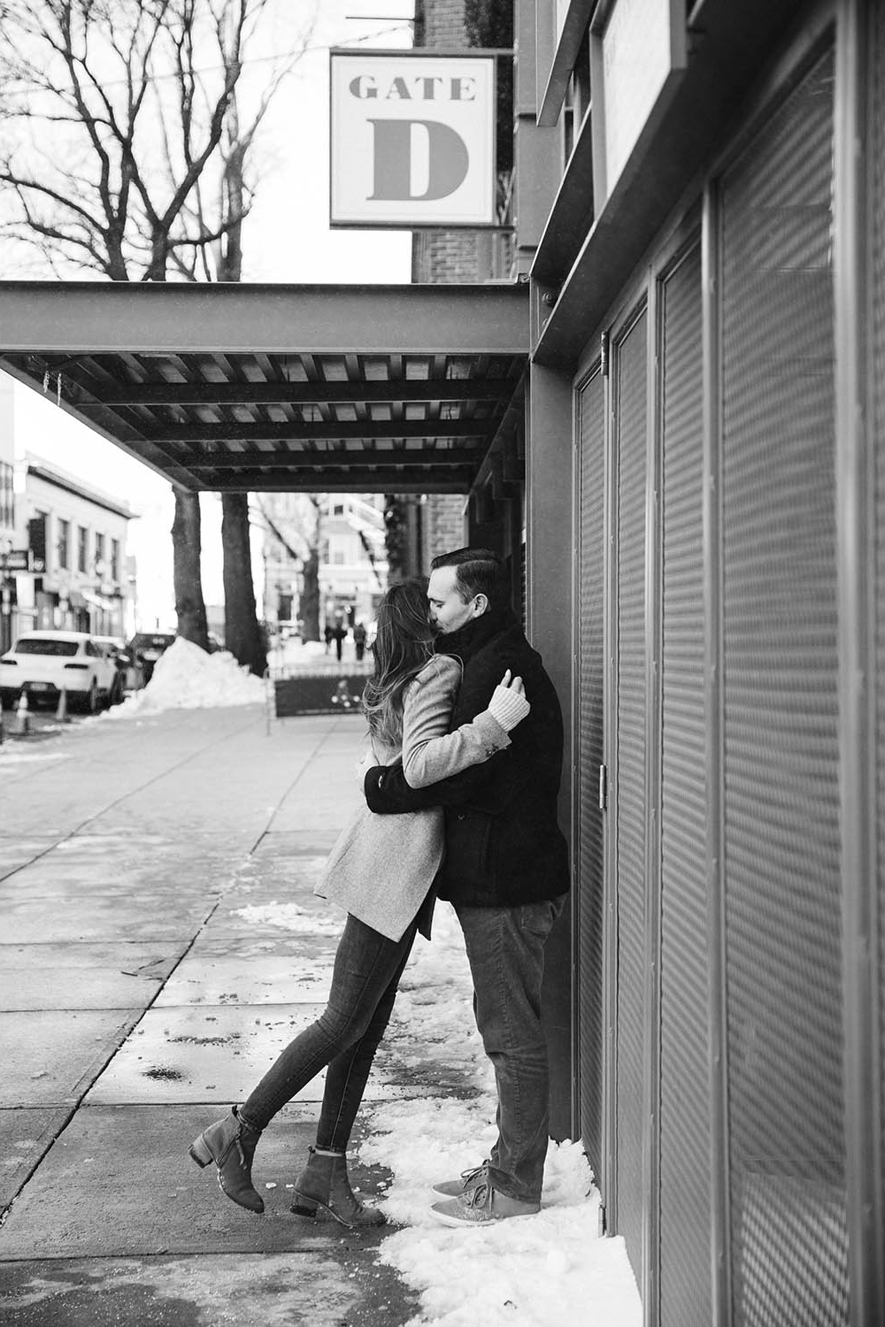 A documentary portrait of a couple hugging at Fenway Park during their Boston engagement session
