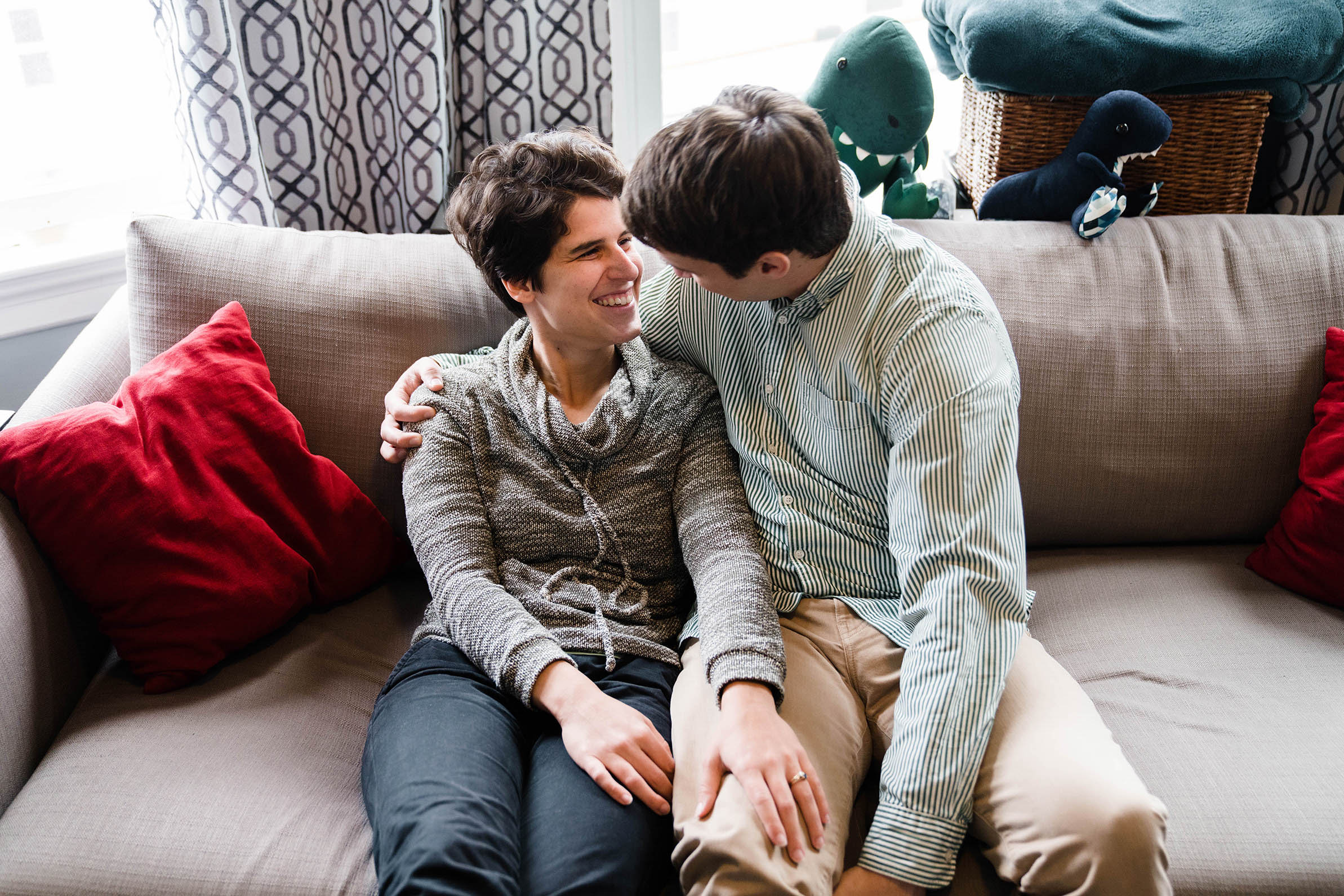 A documentary portrait of a couple hanging out on their couch at home during their Boston engagement session